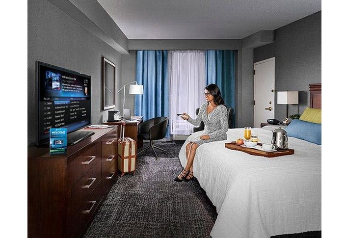 Business woman watching tv in a hotel room