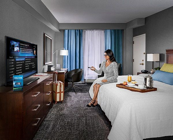 Business woman watching tv in a hotel room